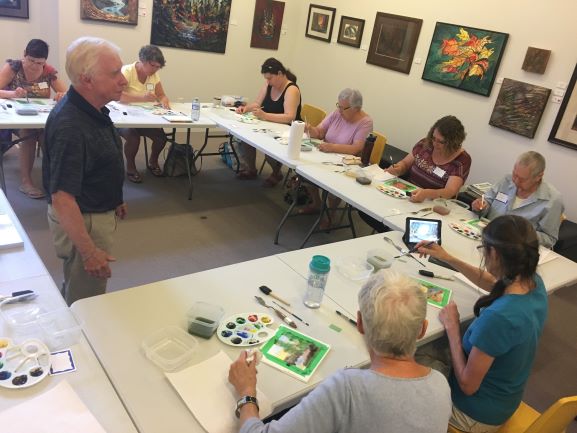 Jack Lockhart watches participants create a painting